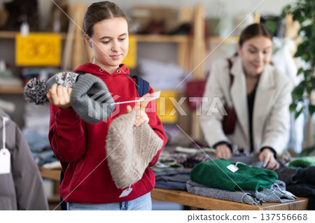 Teenage girl choosing a hat in the store Teenage girl choosing a hat in the store 137556668