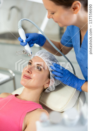 Young girl getting oxygen face therapy in beauty salon. Professional skin care treatment, atomized nutrients to Supplement, skin nutrition. Unique technology of non-injection oxygen mesotherapy Young girl getting oxygen face therapy in beauty salon. Professional skin care treatment, atomized nutrients to Supplement, skin nutrition. Unique technology of non-injection oxygen mesotherapy 137556690