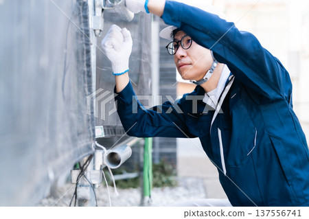 A scaffolder wearing glasses working at a large-scale repair construction site A scaffolder wearing glasses working at a large-scale repair construction site 137556741