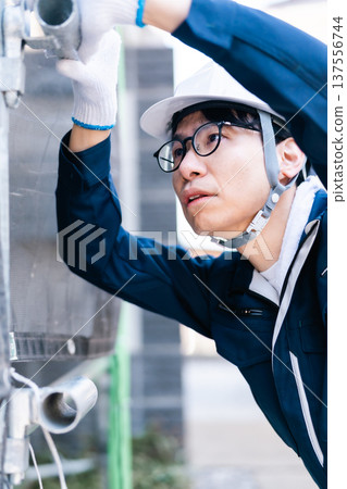 一名戴著眼鏡的鷹架工人在大型維修施工現場工作 137556744