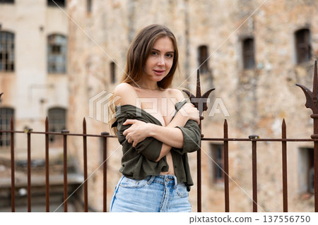 Outdoor fashion - beautiful blonde woman posing near wrought iron fence Outdoor fashion - beautiful blonde woman posing near wrought iron fence 137556750