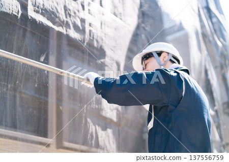 一名戴著眼鏡的鷹架工人在大型維修施工現場工作 一名戴著眼鏡的鷹架工人在大型維修施工現場工作 137556759