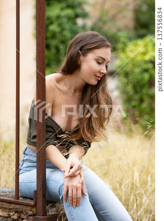Woman in unbuttoned blouse posing near fence 137556834