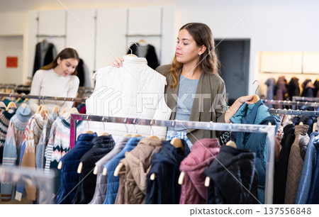 Young woman choosing insulated vest in store 137556848