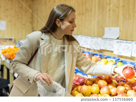 Young woman choosing apples in vegetable shop 137556860