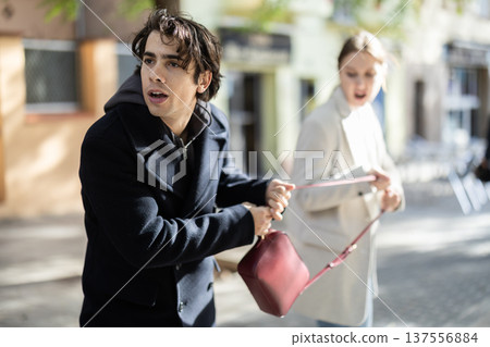 Thief steals girls handbag and runs away with stolen property Thief steals girls handbag and runs away with stolen property 137556884
