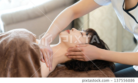 A woman receiving beauty treatment and massage A woman receiving beauty treatment and massage 137556886