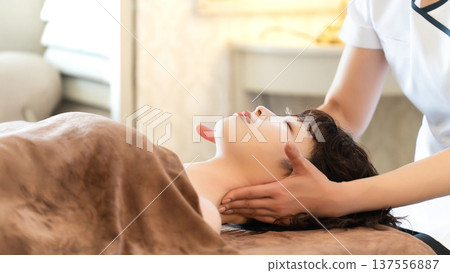 A woman receiving beauty treatment and massage A woman receiving beauty treatment and massage 137556887