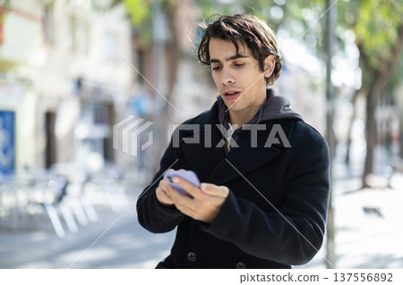 Guy walking along pedestrian street, having nice time Guy walking along pedestrian street, having nice time 137556892