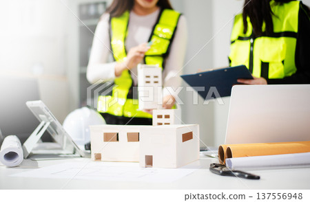 Engineer teams meeting working together wear worker helmets hardhat on construction site in modern city. Engineer teams meeting working together wear worker helmets hardhat on construction site in modern city. 137556948