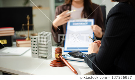 Real estate lawyer reviewing property contract with building model and gavel, concept of investment agreement, mortgage consultation, legal compliance Real estate lawyer reviewing property contract with building model and gavel, concept of investment agreement, mortgage consultation, legal compliance 137556957