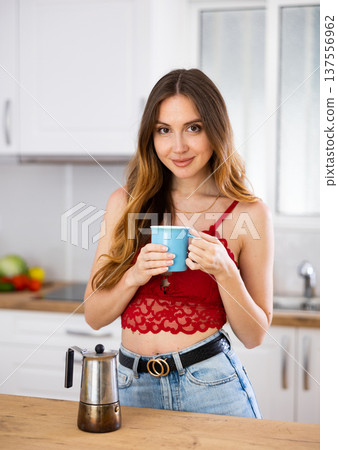 Smiling woman drinking coffee at home 137556962