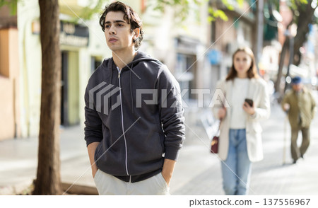 Upset young man walking away from woman on street 137556967