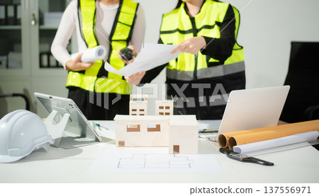 Engineer teams meeting working together wear worker helmets hardhat on construction site in modern city. Engineer teams meeting working together wear worker helmets hardhat on construction site in modern city. 137556971