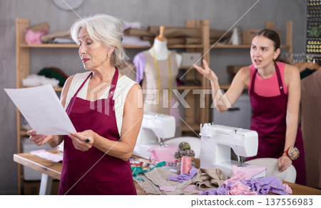 Angry woman boss yells at senior female employee with notice of dismissal in hands Angry woman boss yells at senior female employee with notice of dismissal in hands 137556983