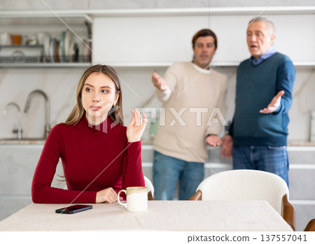 Sad woman not talking after disagreement with father and husband standing behind Sad woman not talking after disagreement with father and husband standing behind 137557041