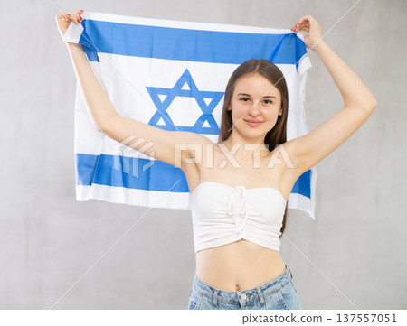 Girl holds unfolded canvas flag of Israel Girl holds unfolded canvas flag of Israel 137557051