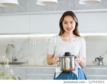Portrait of a housewife preparing soup in a pot in kitchen Portrait of a housewife preparing soup in a pot in kitchen 137557053