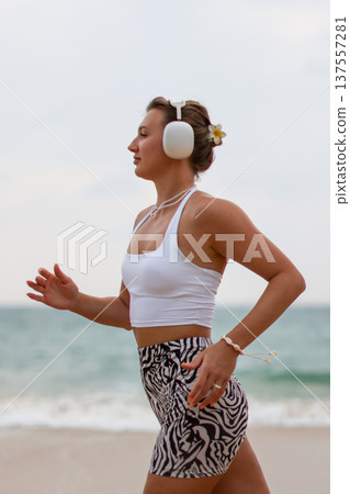 Runner On Beach. Dedicated Athlete Practices Endurance By Jogging Solitary Along Tranquil Ocean Coast 137557281