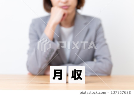 A middle-aged woman in a suit worried about her monthly income A middle-aged woman in a suit worried about her monthly income 137557688