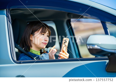 A woman operating a smartphone in a car 137557752