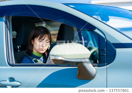 A woman operating a smartphone in a car A woman operating a smartphone in a car 137557801