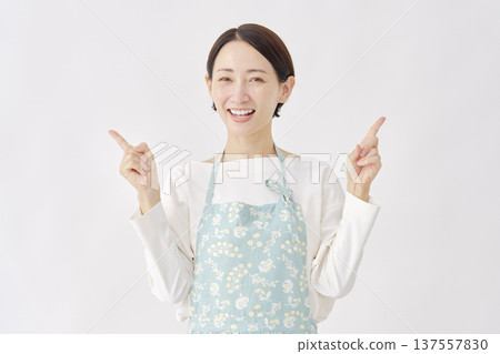 Woman wearing an apron pointing left and right, white background Woman wearing an apron pointing left and right, white background 137557830