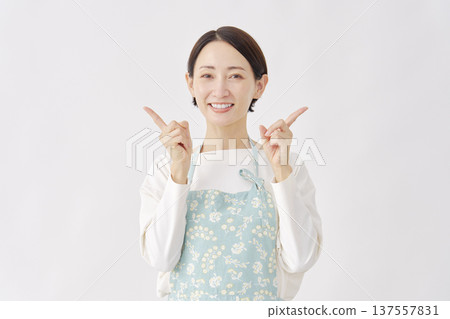 Woman wearing an apron pointing left and right, white background Woman wearing an apron pointing left and right, white background 137557831