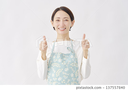 Woman wearing an apron, good sign, white background 137557840