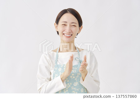 一位身穿圍裙的女子在白色背景上鼓掌 137557860