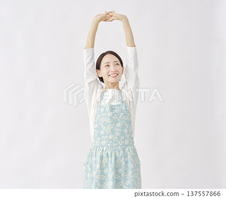 Woman wearing an apron stretching white background Woman wearing an apron stretching white background 137557866