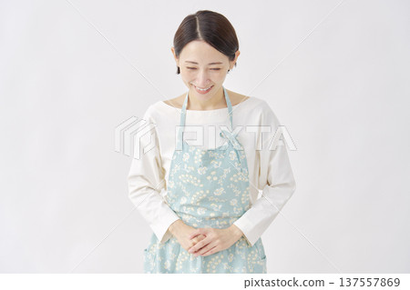 Woman wearing an apron bowing white background 137557869