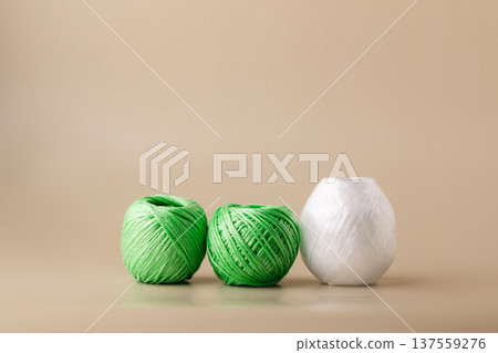 Balls of recycled polyester synthetic thread in various colors on beige background. Eco-friendly living, plastic recycling, reuse Balls of recycled polyester synthetic thread in various colors on beige background. Eco-friendly living, plastic recycling, reuse 137559276