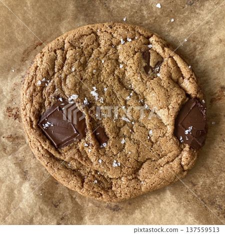 Freshly baked cookies with a golden-brown finish and chocolate chips. Perfectly crisp on the edges with a soft center, offering a delicious, comforting treat for any occasion. 137559513