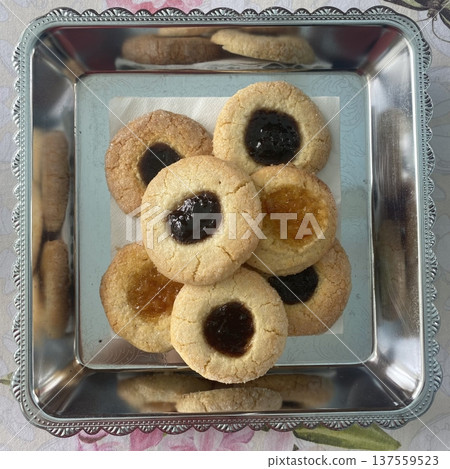 Thumbprint cookies with soft buttery dough shaped into small rounds, each pressed in the center and filled with sweet jam, creating a colorful and classic homemade treat Thumbprint cookies with soft buttery dough shaped into small rounds, each pressed in the center and filled with sweet jam, creating a colorful and classic homemade treat 137559523