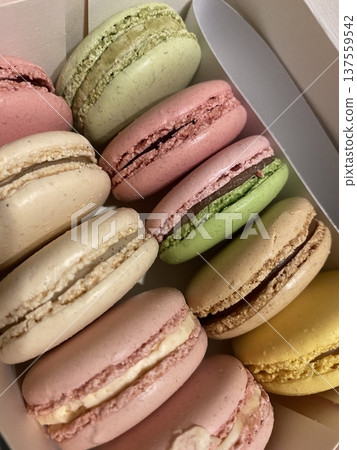 Colorful macarons with a delicate, crispy shell and soft, flavorful filling. Perfect for dessert photography, showcasing these elegant French treats in a variety of flavors and vibrant pastel colors. 137559542