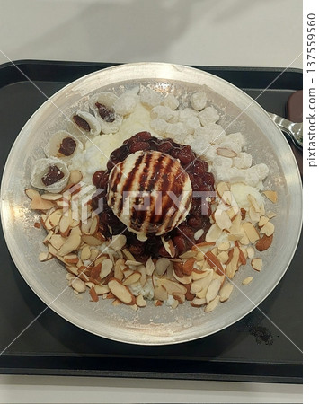 Refreshing bingsu, a Korean shaved ice dessert topped with sweet ingredients like red beans, fruits, and condensed milk. A perfect treat to cool down on hot days. Refreshing bingsu, a Korean shaved ice dessert topped with sweet ingredients like red beans, fruits, and condensed milk. A perfect treat to cool down on hot days. 137559560
