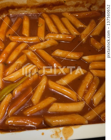 Spicy Korean tteokbokki with chewy rice cakes in a vibrant red sauce, topped with sesame seeds and green onions. A popular street food known for its addictive flavor and satisfying texture. Spicy Korean tteokbokki with chewy rice cakes in a vibrant red sauce, topped with sesame seeds and green onions. A popular street food known for its addictive flavor and satisfying texture. 137560652