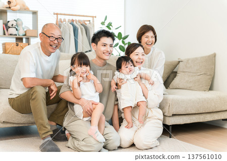Three generation family relaxing in the living room, Family (gathering) Three generation family relaxing in the living room, Family (gathering) 137561010
