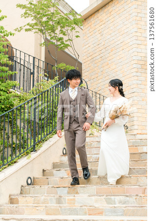 新娘和新郎在婚禮儀式上走下教堂的樓梯(新娘、婚禮、招待會) 新娘和新郎在婚禮儀式上走下教堂的樓梯(新娘、婚禮、招待會) 137561680