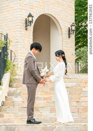 Bride and groom facing each other with bouquets (wedding, bridal, couple) 137561681