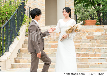新娘和新郎在婚禮儀式上走下教堂的樓梯(新娘、婚禮、招待會) 新娘和新郎在婚禮儀式上走下教堂的樓梯(新娘、婚禮、招待會) 137561684