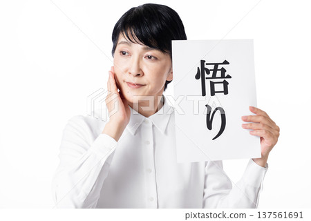 一位老婦人陷入沉思，她手中拿著一張寫著「頓悟」二字的紙條，一隻手撫摸著臉頰。 137561691