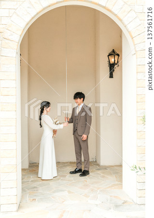 Bride and groom in a dress holding wedding bell strings in a wedding chapel Bride and groom in a dress holding wedding bell strings in a wedding chapel 137561716