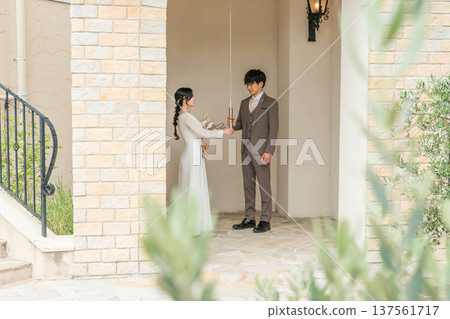 Bride and groom in a dress holding wedding bell strings in a wedding chapel Bride and groom in a dress holding wedding bell strings in a wedding chapel 137561717