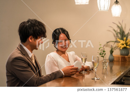 一名男子在吧台向一位微笑的女子出其不意地求婚。 137561877