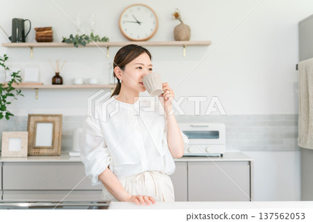 一位女士在廚房喝咖啡、茶和熱水。 一位女士在廚房喝咖啡、茶和熱水。 137562053