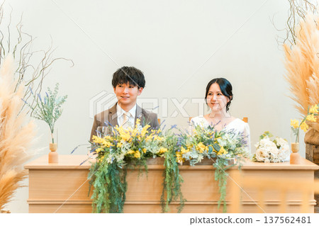 新郎新娘在婚宴的高砂席上聆聽問候 新郎新娘在婚宴的高砂席上聆聽問候 137562481