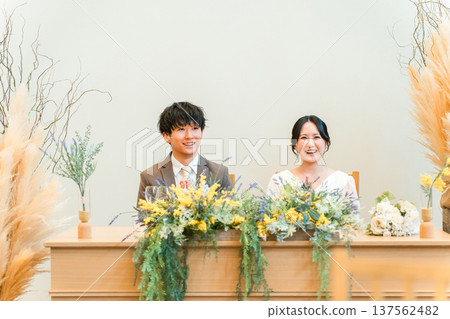 新郎新娘在婚宴的高砂席上聆聽問候 新郎新娘在婚宴的高砂席上聆聽問候 137562482
