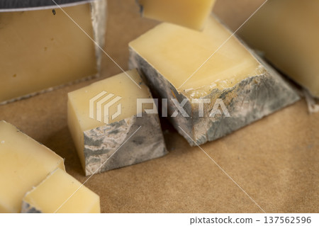 an old spoiled orange cheese with a lot of colorful mold, an inedible and dangerous cheese that was spoiled during the improper storage, cheese is covered with mold dangerous to health 137562596